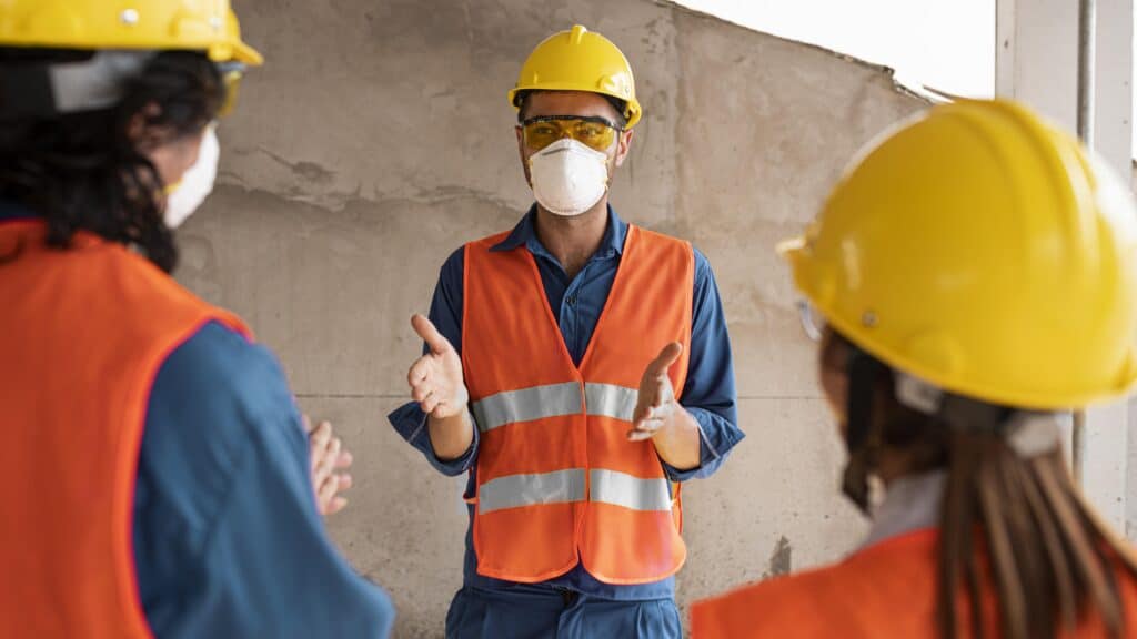 a group of people wearing safety gear and face masks during a Australia WHS act briefing
